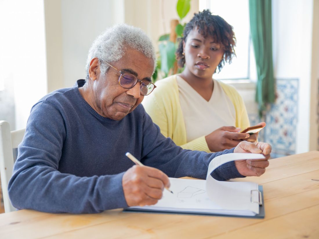 A client working through his own support plan at the kitchen table with his Keana Care worker
